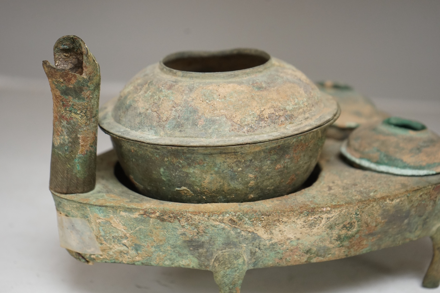 Four Chinese bronze zoomorphic stoves, Han Dynasty, 22cm, together with a Han Dynasty bronze brazier and vessels, width 22.5cm, (5). Condition - poor to fair.